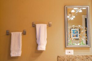 Elegant contemporary bathroom featuring white towels and a decorative mirror reflection, enhancing the minimalist design.
