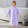 Back view of a child wearing an aqua purple striped hooded cotton poncho towel
