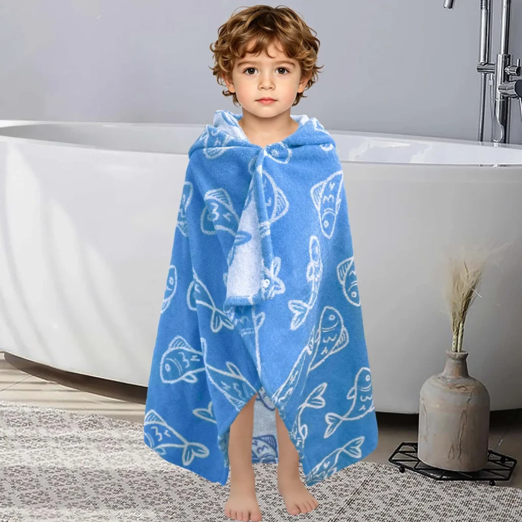 Toddler wearing a blue fish print towel after bath