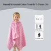 Child wearing a pink striped hooded towel beside a swimming pool