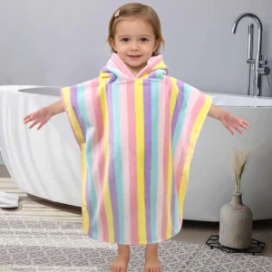 Toddler wearing a colorful striped hooded poncho towel at home