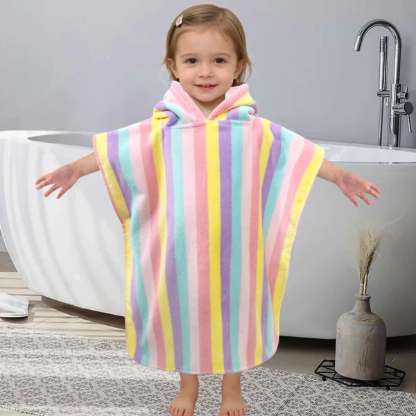 Toddler wearing a colorful striped hooded poncho towel at home